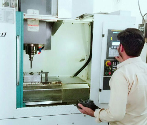 VMC machining process with vertical cutting tool working on metal part